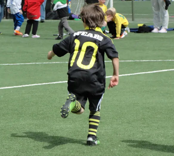 liten pojke spelar fotboll